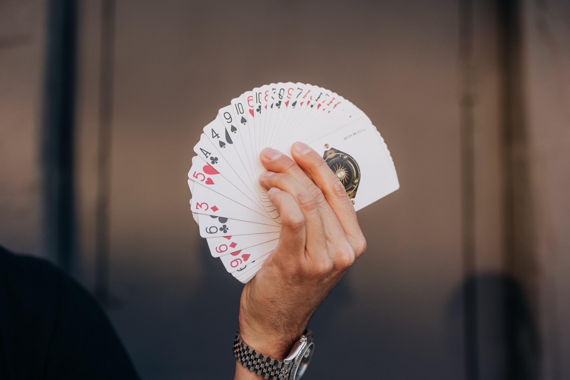 A magician's hand fanning a deck of playing cards
